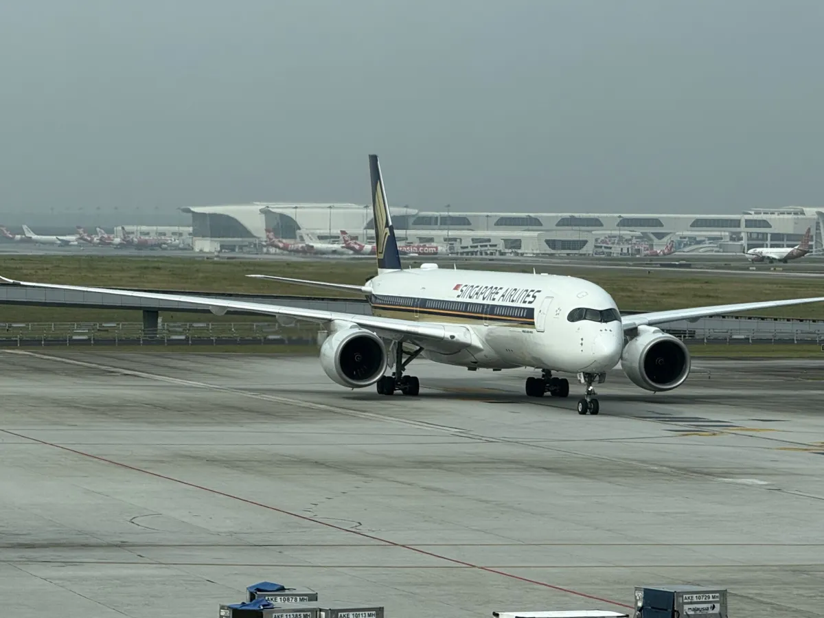 A Singapore Airlines Airbus A350-900 taxiing head-on, gold Singapore Airlines titles on a white fuselage