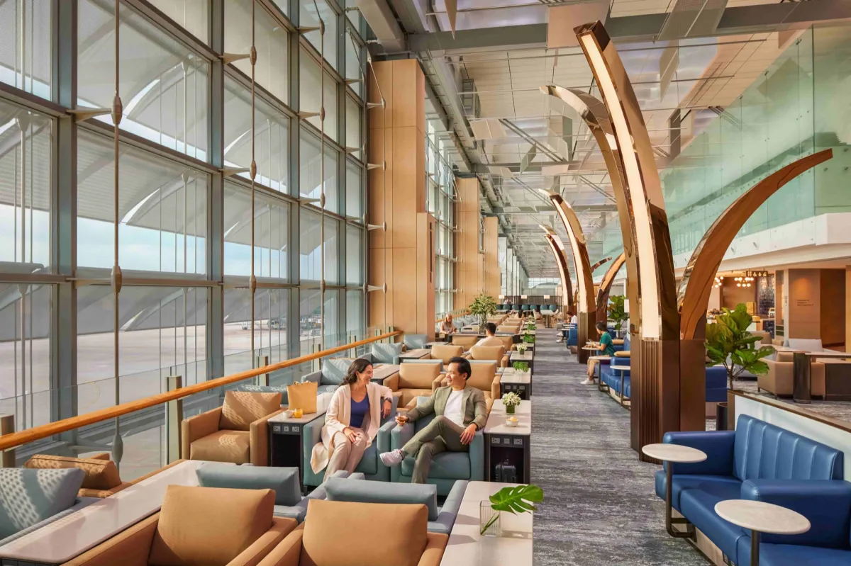 Bright SilverKris lounge seating area with floor-to-ceiling windows overlooking the Changi Airport apron